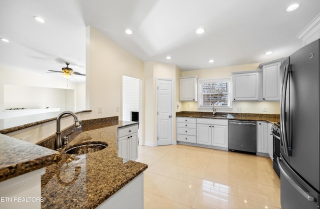 kitchen featuring appliances with stainless steel finishes, recessed lighting, a sink, and dark stone countertops