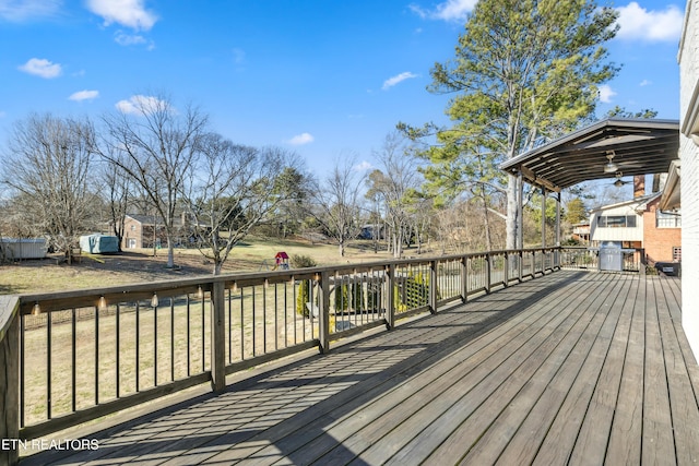 deck with an outbuilding, a yard, and a ceiling fan