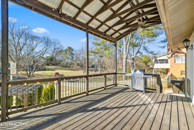 wooden deck with a grill and ceiling fan