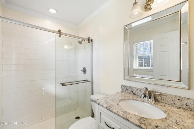 bathroom featuring ornamental molding, tiled shower, vanity, and toilet