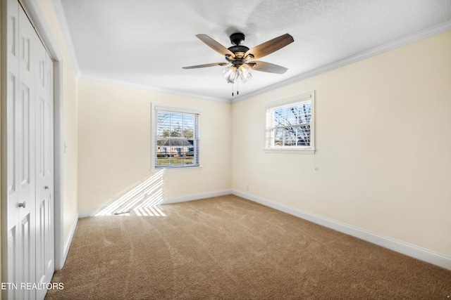 unfurnished bedroom with crown molding, a closet, baseboards, and carpet flooring