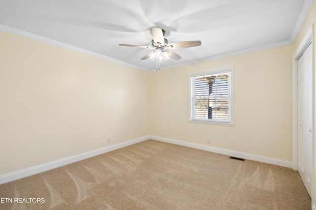 unfurnished room featuring baseboards, ornamental molding, visible vents, and light colored carpet