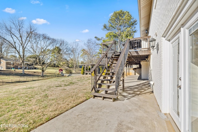 view of yard with a wooden deck, stairs, fence, and a patio