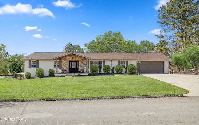 ranch-style house featuring driveway, stone siding, an attached garage, a front yard, and stucco siding