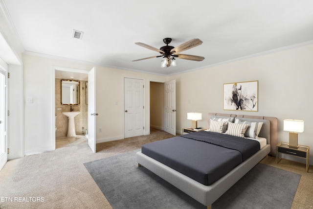 bedroom featuring light carpet, visible vents, baseboards, ensuite bath, and crown molding