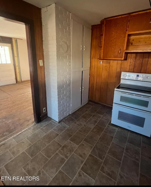 kitchen with stone finish flooring, range with two ovens, and brown cabinets