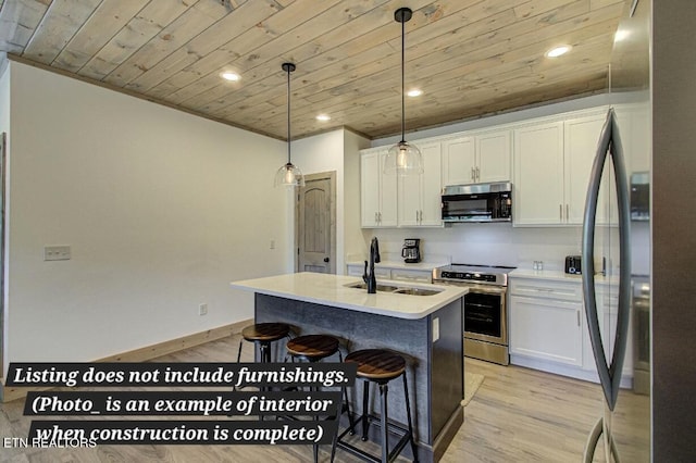 kitchen featuring stainless steel appliances, light countertops, white cabinets, and a kitchen island with sink