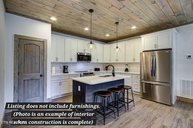 kitchen featuring stainless steel appliances, light countertops, visible vents, and white cabinetry