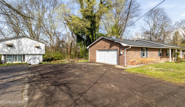 view of home's exterior with aphalt driveway, an attached garage, and brick siding