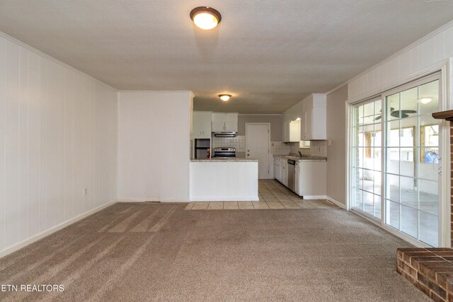 unfurnished living room with crown molding, light colored carpet, baseboards, and a textured ceiling