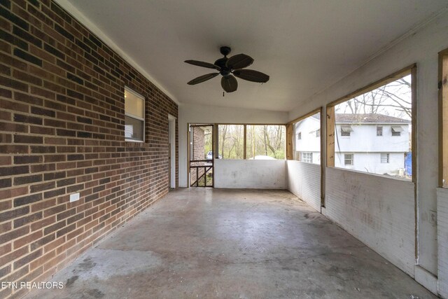 unfurnished sunroom featuring ceiling fan