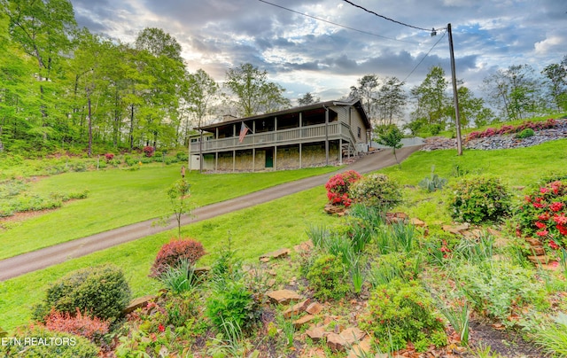 exterior space featuring a front yard and a wooden deck