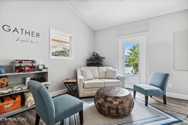 sitting room with baseboards, wood finished floors, plenty of natural light, and vaulted ceiling