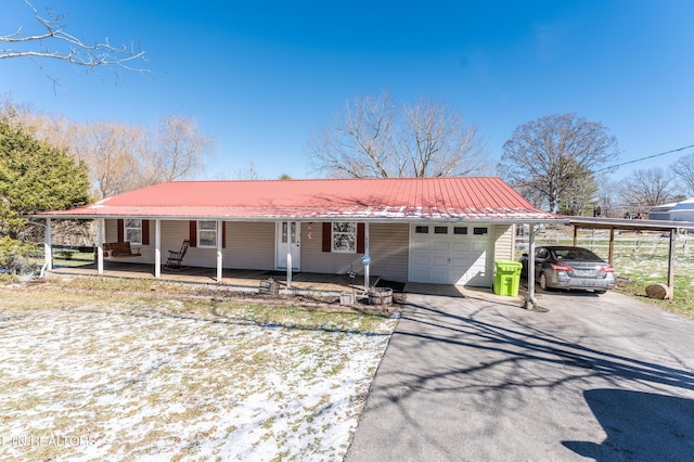 view of front of property featuring a porch, metal roof, driveway, and a garage