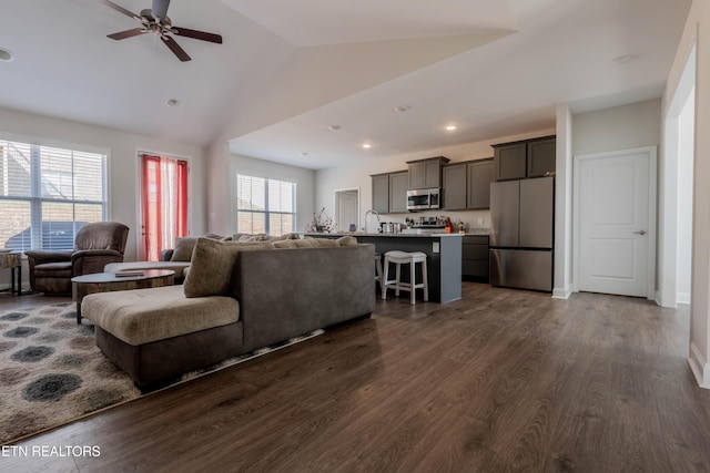 living area with dark wood-style floors, vaulted ceiling, a ceiling fan, and recessed lighting