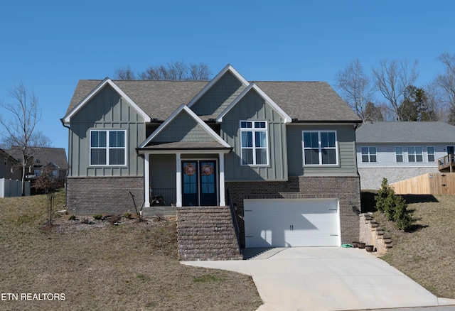 view of front of property featuring concrete driveway, brick siding, board and batten siding, and french doors