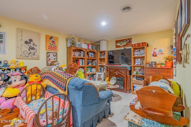 carpeted living room featuring visible vents and a glass covered fireplace