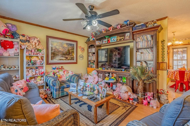 living area with a textured ceiling, ceiling fan with notable chandelier, wood finished floors, and crown molding