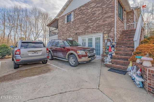 view of property exterior with brick siding and stairway