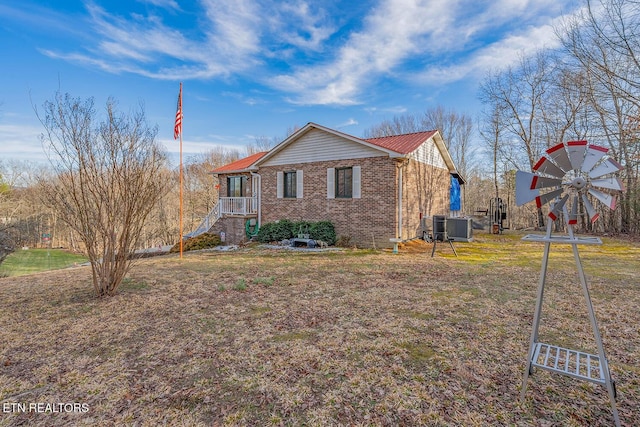 view of side of property with cooling unit and brick siding