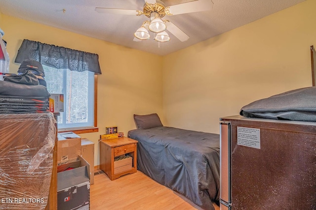 bedroom featuring ceiling fan, a textured ceiling, and wood finished floors