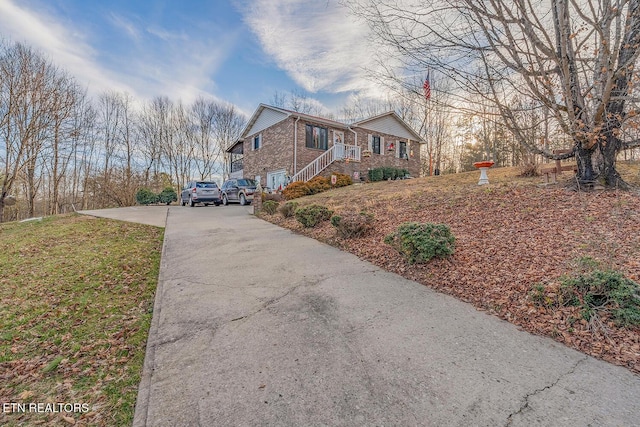 view of side of home featuring brick siding and driveway