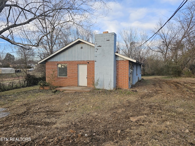 exterior space with a chimney and brick siding