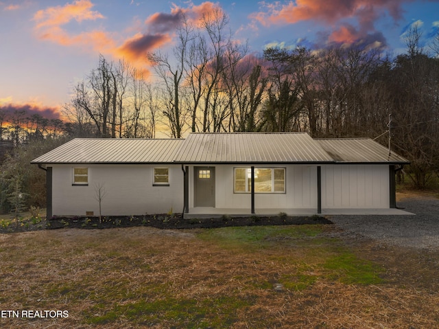 ranch-style house with metal roof and a front yard