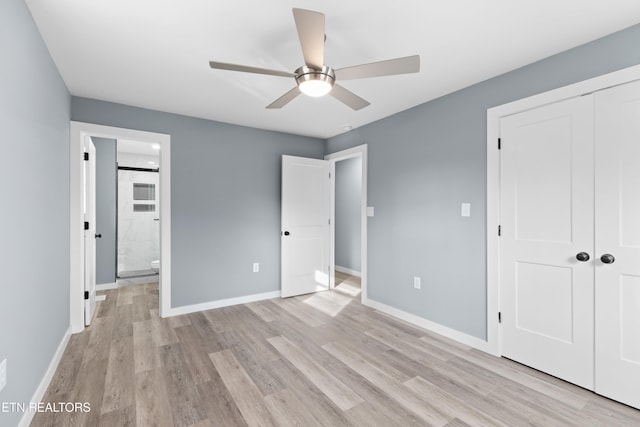 unfurnished bedroom with light wood-type flooring, a closet, baseboards, and ensuite bathroom