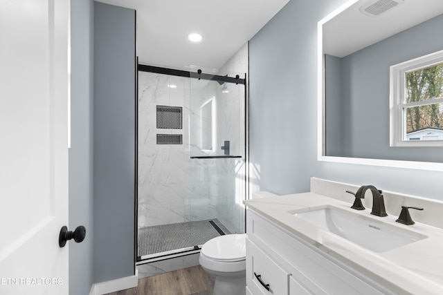 full bath featuring toilet, a marble finish shower, visible vents, and vanity