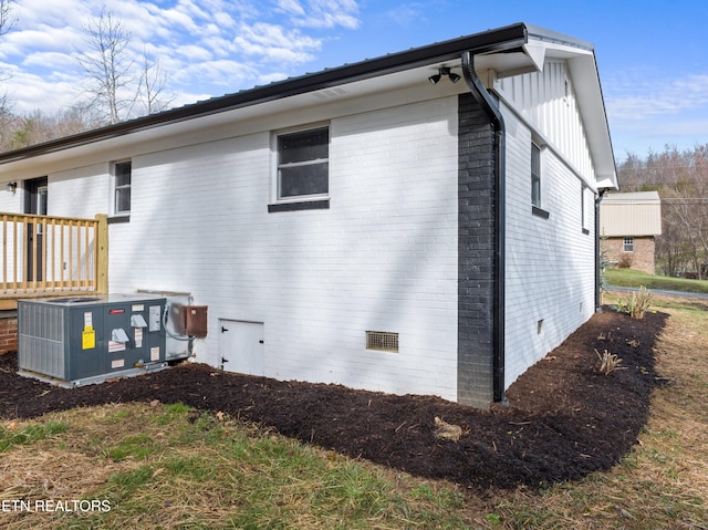 view of property exterior with central AC unit, crawl space, and brick siding