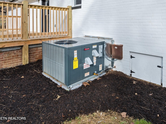 exterior details featuring central AC and brick siding