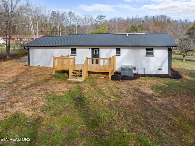 back of property with a deck, metal roof, a lawn, and cooling unit