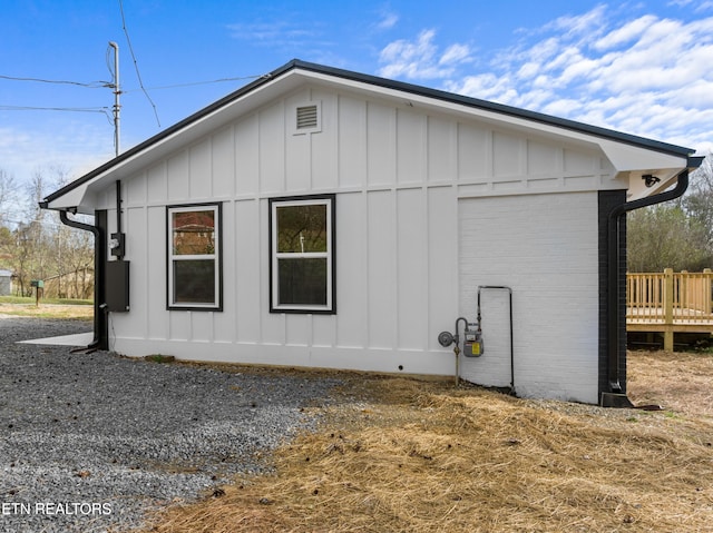 view of property exterior with board and batten siding and brick siding