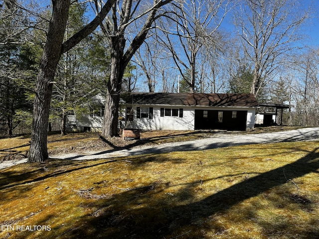 view of front of property featuring a front lawn and a carport