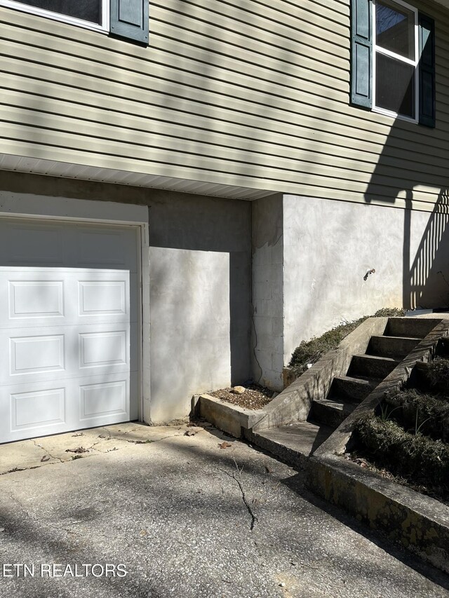 doorway to property with a garage and stucco siding