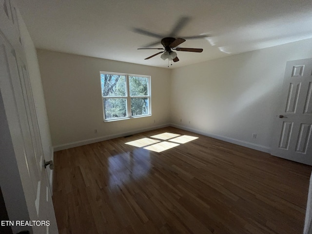 unfurnished room with ceiling fan, baseboards, and dark wood finished floors