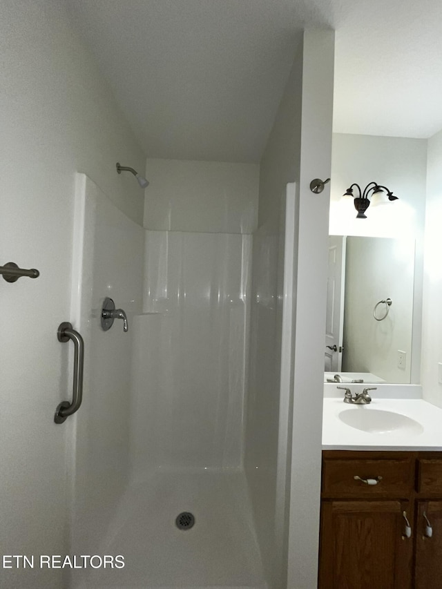 bathroom with a shower stall and vanity