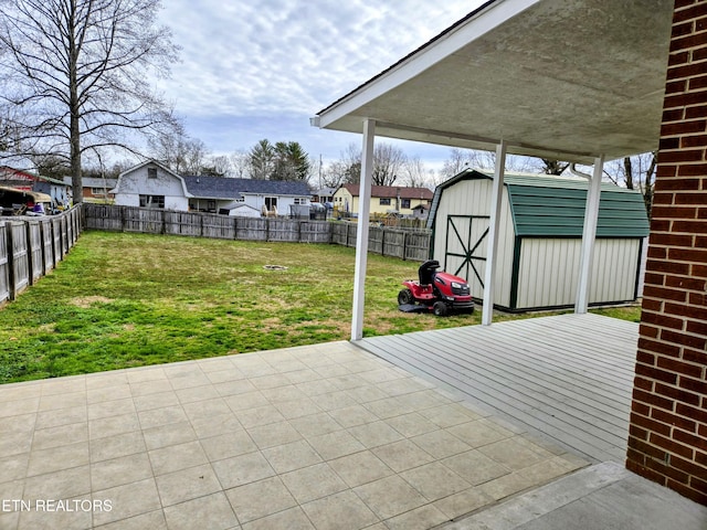 view of patio / terrace featuring a storage unit, an outdoor structure, a fenced backyard, and a residential view