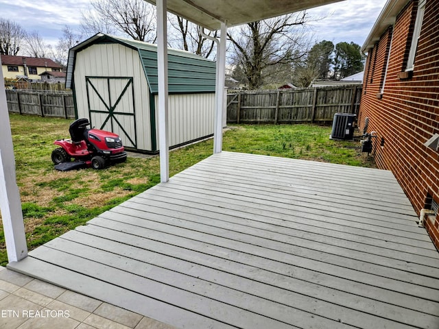 wooden deck with cooling unit, a fenced backyard, an outdoor structure, and a storage shed