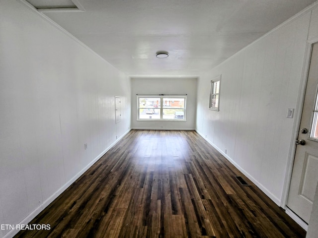 unfurnished room featuring ornamental molding, dark wood finished floors, and baseboards