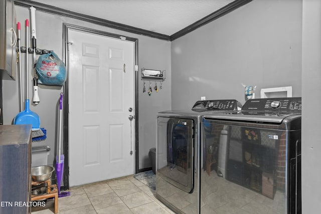 laundry area featuring light tile patterned floors, a textured ceiling, laundry area, washer and clothes dryer, and crown molding