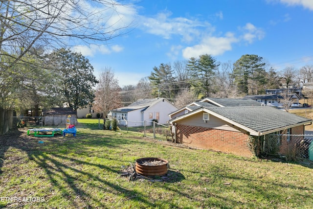 view of yard featuring an outdoor fire pit and fence