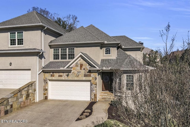 view of front of property featuring stone siding, a shingled roof, concrete driveway, and stucco siding