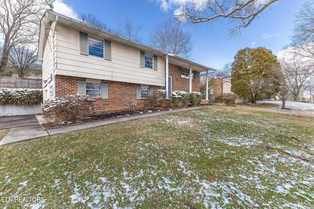 bi-level home with brick siding and a yard