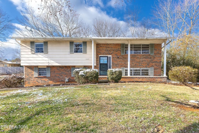 raised ranch with brick siding and a front lawn