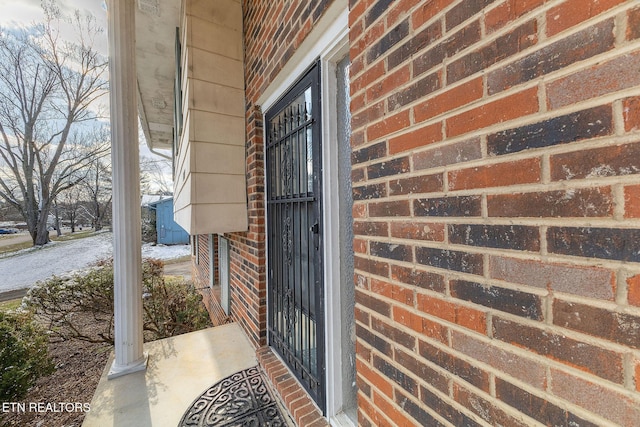 doorway to property with brick siding