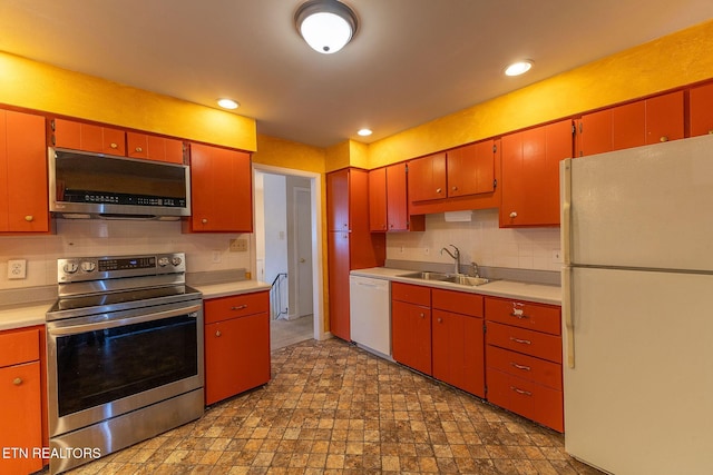 kitchen with appliances with stainless steel finishes, light countertops, and a sink