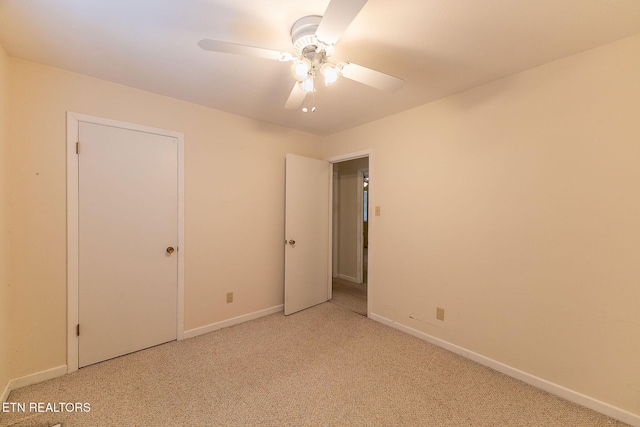 unfurnished bedroom with baseboards, a ceiling fan, and light colored carpet