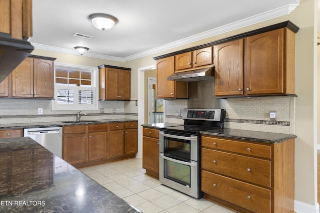 kitchen featuring visible vents, appliances with stainless steel finishes, brown cabinets, under cabinet range hood, and a sink